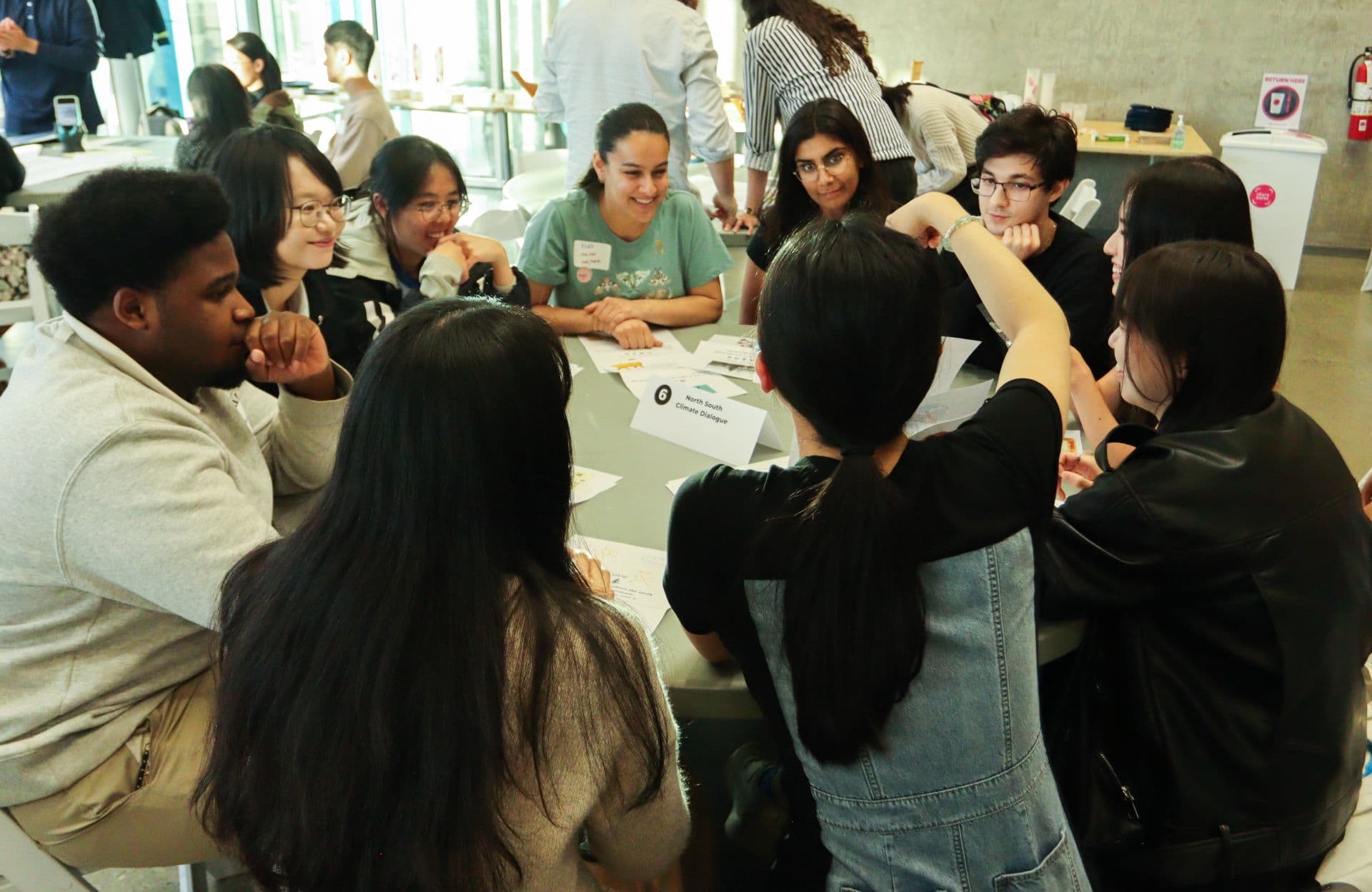 Participants smiling and discussing a climate learning card together.