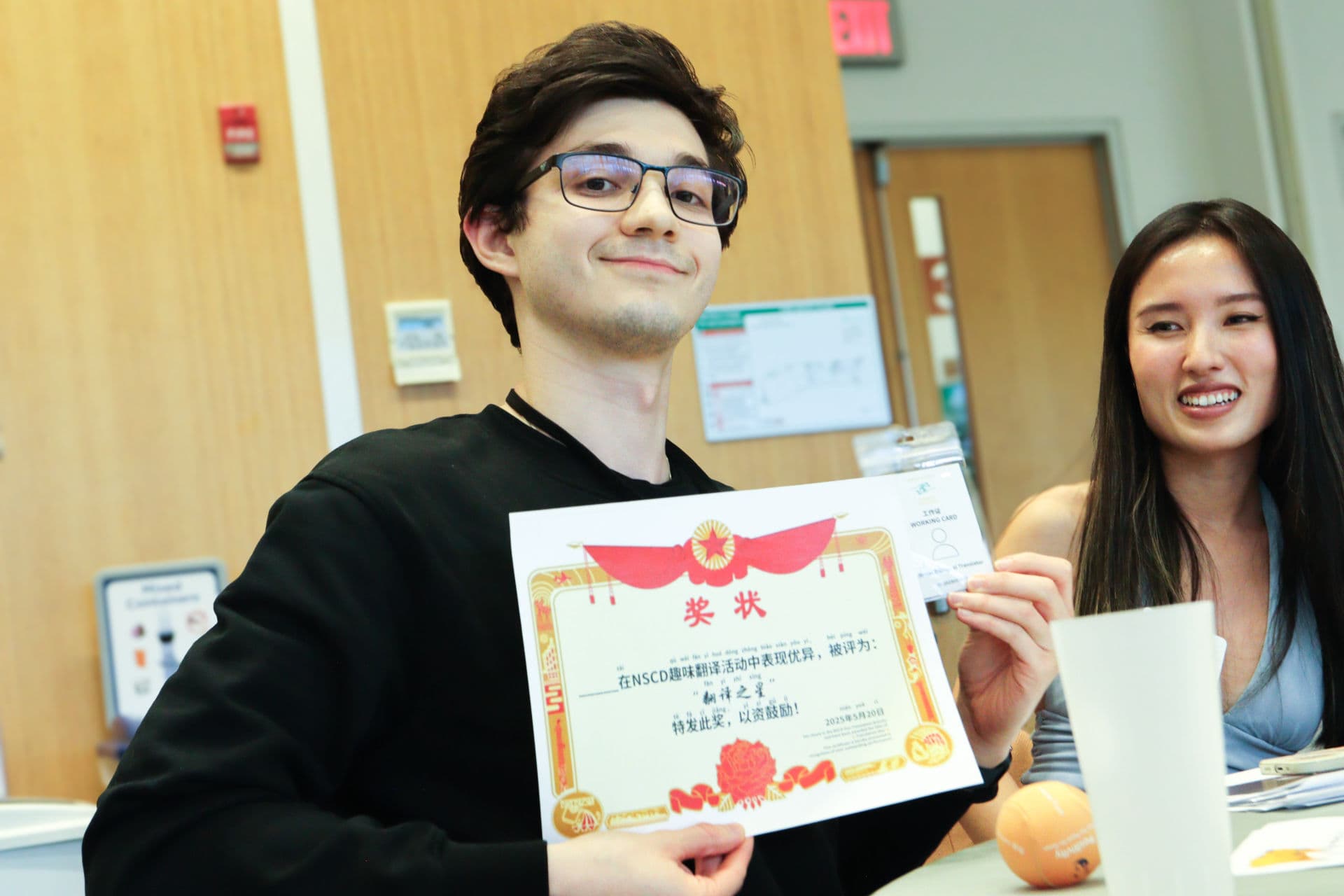 Two participants holding a playful translator badge after joining the NSCD activity.