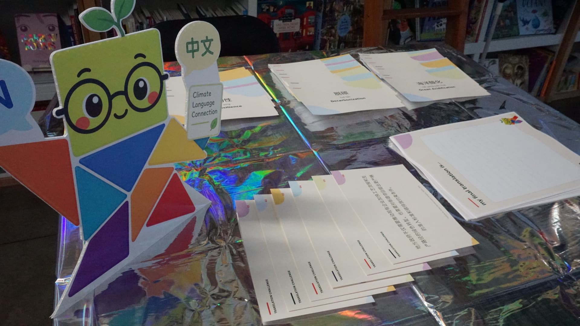 Bilingual climate vocabulary translation cards laid out on the workshop table.