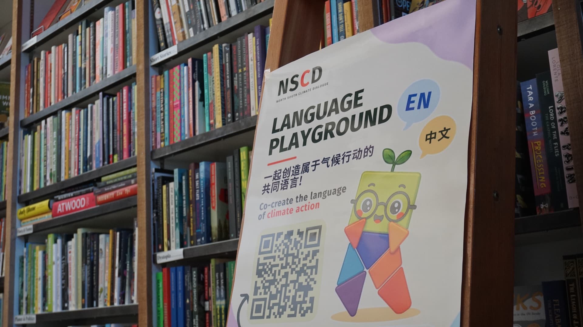 NSCD Language Playground poster on an easel at Upstart & Crow Studio, Granville Island. Photo by Ahmad Abousaleh.